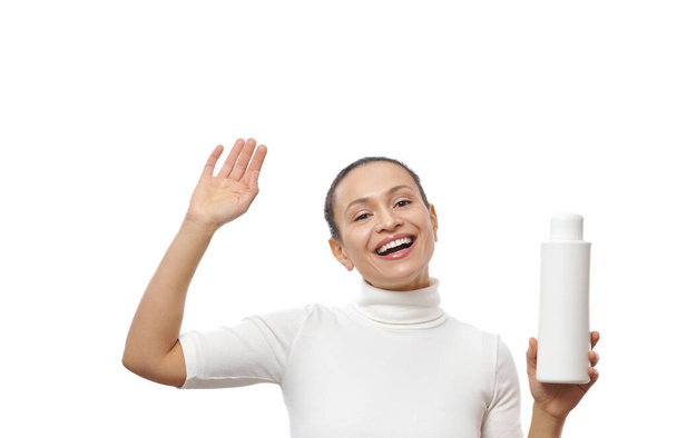 Смеющаяся женщина с косметическим продуктом на белом фоне. - Фото, изображение