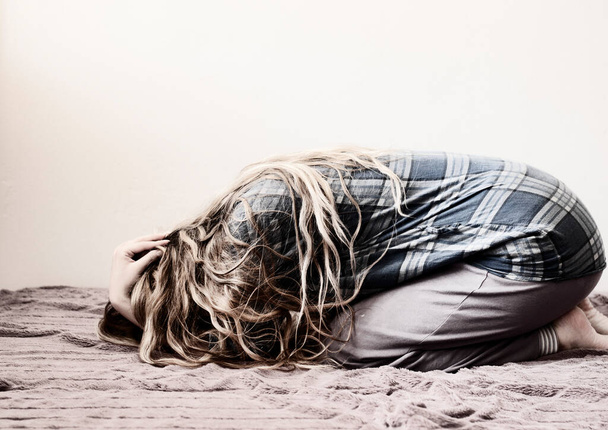 Сумна молода жінка на ліжку
 - Фото, зображення