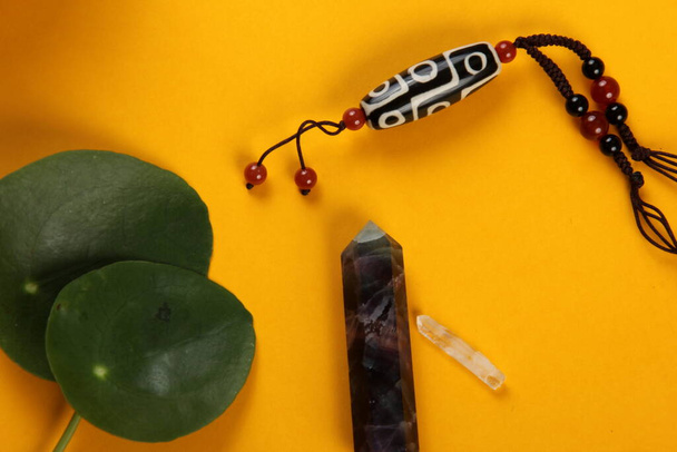 Тибетский бусинка бусинка амулет ожерелье, тибетская чаша пения и другие символы успеха и процветания на желтом фоне - Фото, изображение