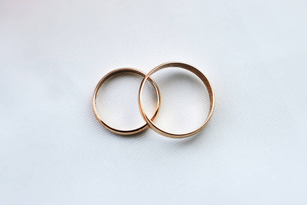 anillos de boda de oro en una superficie de tela blanca. preparándose para la boda. primer plano, macro - Foto, Imagen