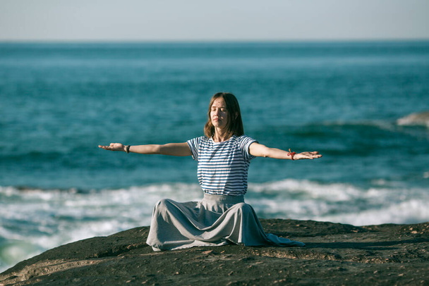 ヨガの女性が海の海岸で瞑想する. - 写真・画像