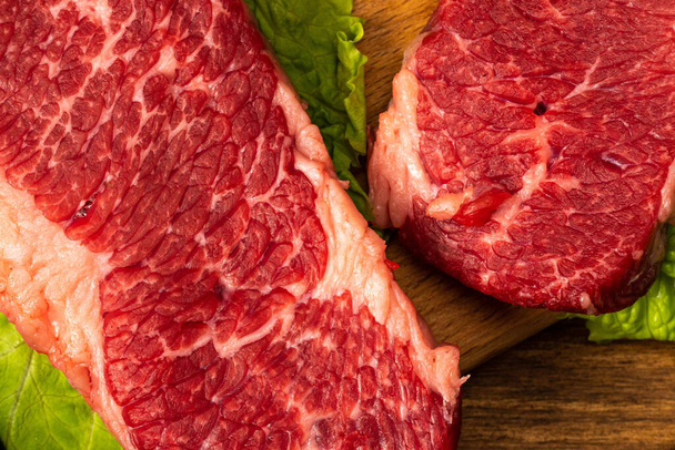 Syrové mramorované hovězí steaky se salátem, červenou cibulí, česnekem a okurkou. - Fotografie, Obrázek