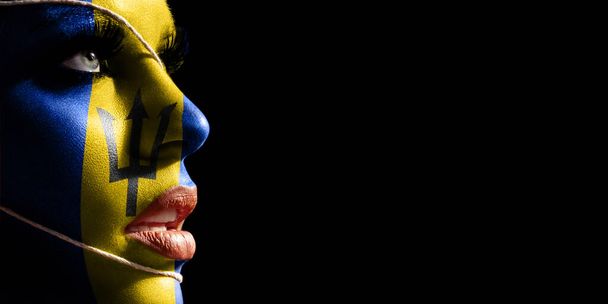 Barbados flag painted on a face of a young woman, national flag on face - Foto, imagen