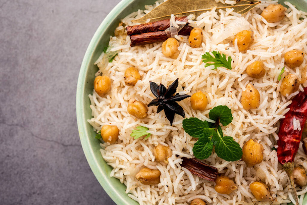 Вкусный пряный Чана Пулао или Пулав или плов, приготовленный из риса Басмати и гороха черного или белого с пряностями - Фото, изображение