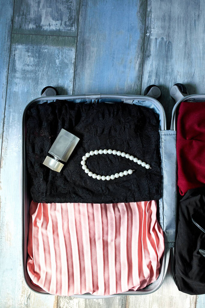Pakkaus matkalaukku kotona naisen kohteita, tarvikkeet matkalaukussa matka, matka, loma. Kopioi tila. - Valokuva, kuva