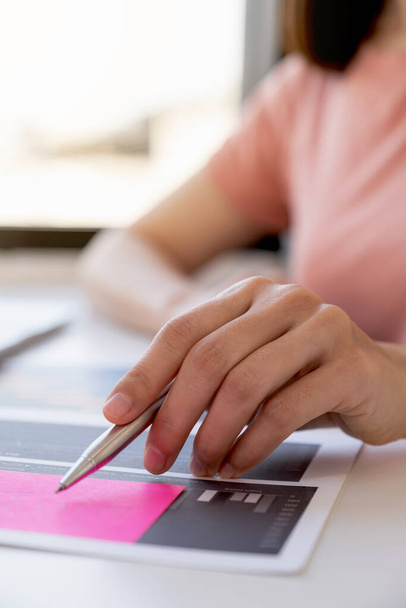 Азия женщина держит ручку, анализ графика с калькулятором и ноутбуком в домашнем офисе для установления сложных бизнес-целей и планирование достижения новой цели. - Фото, изображение