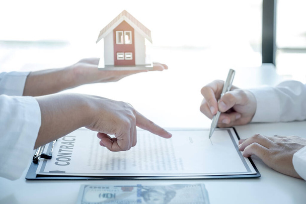 Agent nieruchomości ręcznie wskazując i wyjaśnia umowę biznesową, czynsz, zakup, hipotekę, pożyczkę lub ubezpieczenie domu do kupującego człowieka. - Zdjęcie, obraz