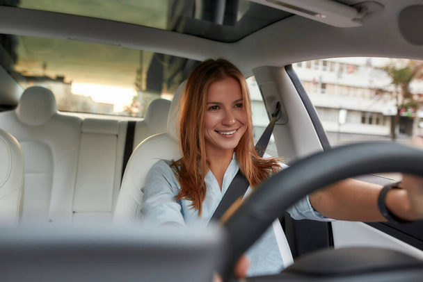 Portrait of smiling young woman driving modern car - Foto, immagini