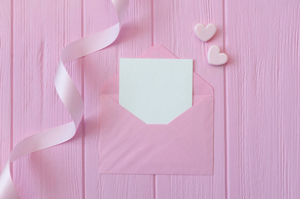 Wedding or birthday mock up scene. Blank open envelope with place for text for greeting card copyspace. Valentines card with two hearts on pink background. Flat lay, top view - Photo, Image