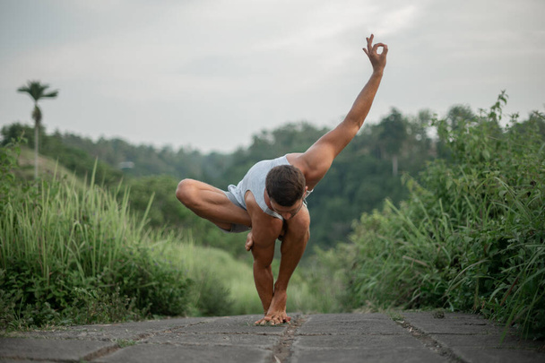 Hombre practica Yoga práctica y meditación al aire libre. - Foto, imagen