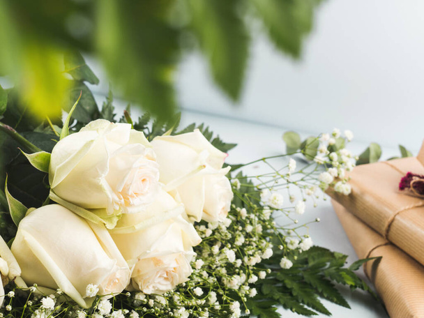 Weiße Rosen Strauß als Geschenk an einem Feiertag auf grau - Foto, Bild
