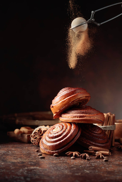 Freshly baked sweet buns sprinkled with cinnamon powder. Copy space. - Foto, Bild