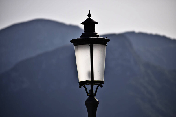 背景にぼやけた山のあるルンゴマーレ・トリエステの街路灯 - 写真・画像