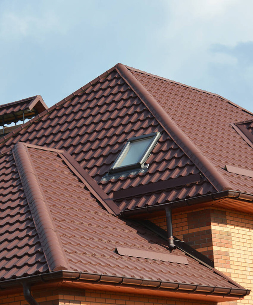 Zbliżenie obszaru problemu hydroizolacji dachów metalowych z błyskami dachowymi, skomplikowanym dachem z dolinami, oknem dachowym, osłonami śnieżnymi lub korkami śnieżnymi. - Zdjęcie, obraz