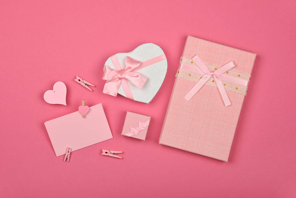 Valentine szablon pudełka w kształcie serca z kokardą wstążką szyfonową i notatką papierową na różowym tle papieru owijającego, zbliżenie płaski leżak, podwyższony widok z góry, bezpośrednio nad - Zdjęcie, obraz
