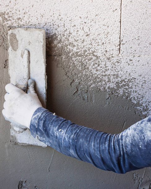 Worker plastering tool plaster marble on interior plaster rough - Фото, зображення