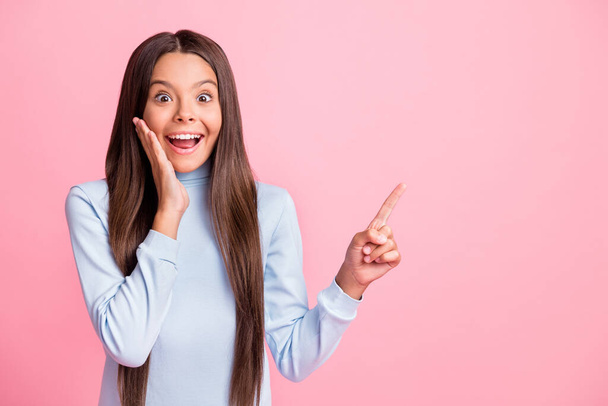 Photo of astonished cute brunette hair girl direct banner feedback finger hand on cheek isolated on pink color background - 写真・画像