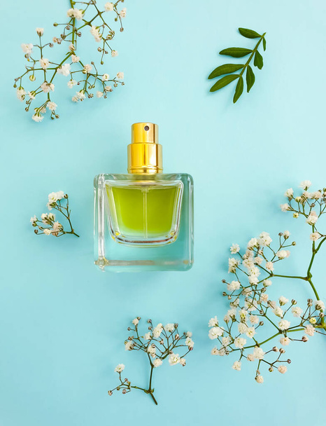 bottle perfume flower on a colored background - Fotó, kép