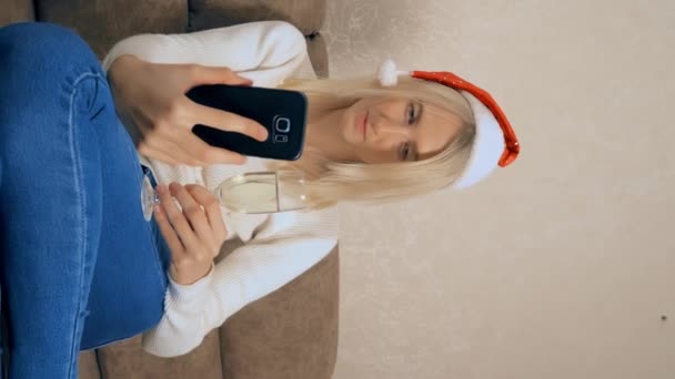 блондинка общается через смартфон с родственниками или друзьями на Рождество. - Кадры, видео