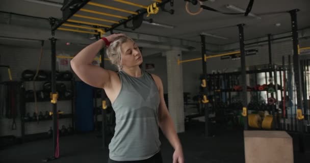 Sportswoman strečink krk v tělocvičně - Záběry, video