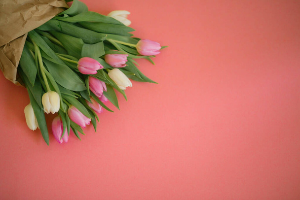 Tulpen op een roze achtergrond voor een Vrouwendag, Moederdag, 8 maart of Valentijnsdag. Een close-up. Het concept van vakantie en goede morgen wensen. - Foto, afbeelding
