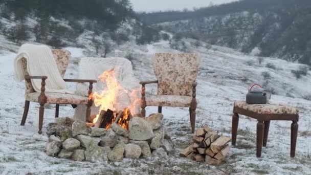 Feuer im Schnee mit den bequemen Sesseln für ein schönes Paar. - Filmmaterial, Video