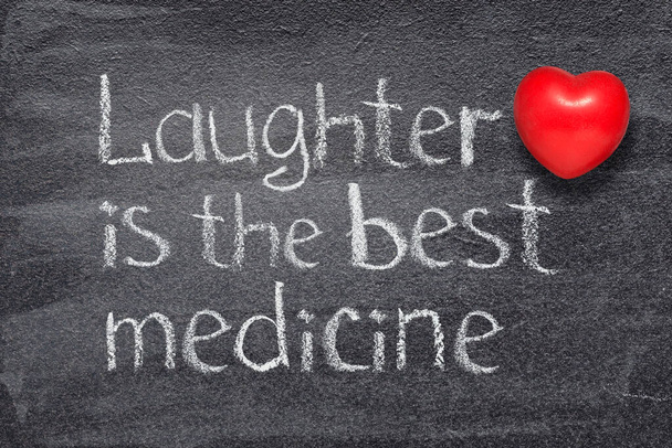Το γέλιο είναι η καλύτερη ιατρική παροιμία γραμμένη στον πίνακα με το κόκκινο σύμβολο της καρδιάς. - Φωτογραφία, εικόνα