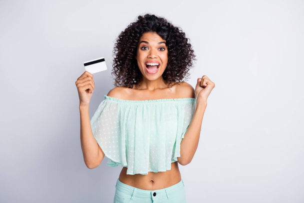 Photo portrait of cheerful girl holding credit card in one hand isolated on white colored background - Foto, immagini