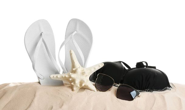 Different beach accessories on sand against white background - Foto, Imagem