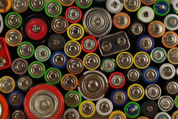 Preparações para reciclagem ou utilização. Dezenas de tipos, tamanhos, cores de baterias e acumuladores usados.  - Foto, Imagem