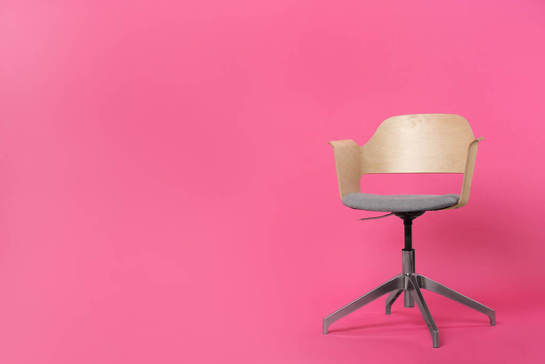 Pohodlné kancelářské křeslo na růžovém pozadí, prostor pro text - Fotografie, Obrázek