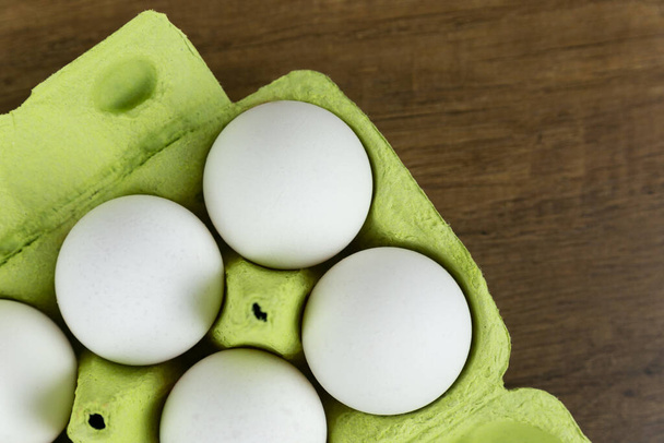 Κάτοψη των λευκών αυγών κοτόπουλου σε ανοιχτό χαρτόκουτο. Φρέσκα αυγά κοτόπουλου. Αυγά σε ένα κουτί, κοντινό. Συστατικά μαγειρικής. - Φωτογραφία, εικόνα