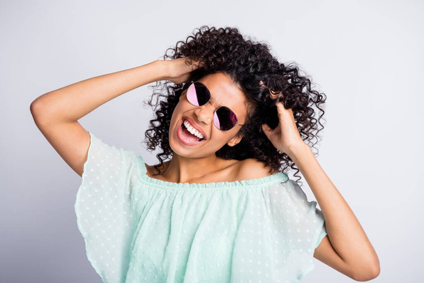 Photo portrait of funky black skinned girl curly hairstyle laughing dancing in sunglass in summer isolated on grey color background - Φωτογραφία, εικόνα