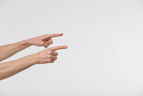 Κοντινό πλάνο των αρσενικών χεριών δείχνουν με δείκτη δάχτυλα στο κενό χώρο ή ένοχος, απομονώνονται σε λευκό φόντο.  - Φωτογραφία, εικόνα