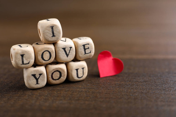 Cubes with words I Love You and paper heart on wooden table - Zdjęcie, obraz