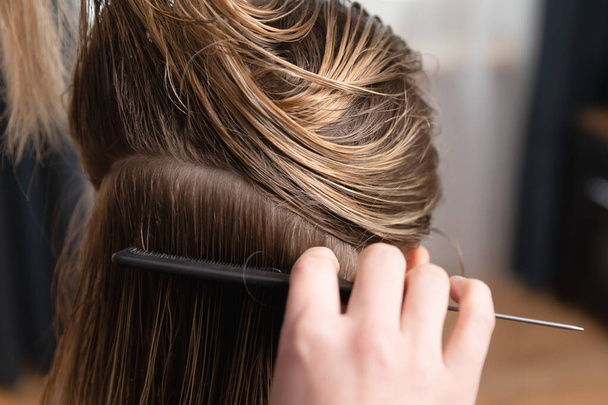 Friseur überprüft blonde Frauen nachgewachsene Wurzeln. Vorbereitung auf Haarfärbung und Haarschnitt zu Hause oder im Salon. - Foto, Bild