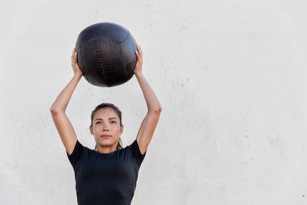 Fitnessmädchen trainiert Schultern mit Medizinball - Foto, Bild