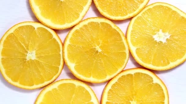 Ein wirbelnder Hintergrund aus geschnittenen Orangen auf weißem Hintergrund. Der Blick von oben. - Filmmaterial, Video