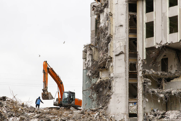 Edifício do antigo hotel demolição para nova construção, usando uma escavadeira-destruidores especiais. Completa demolição altamente mecanizada de estruturas de construção.  - Foto, Imagem