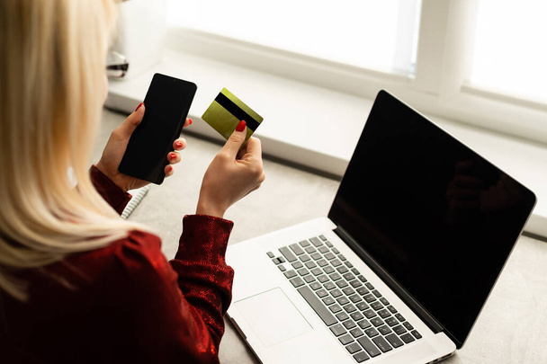 счастливая женщина делает покупки онлайн с помощью ноутбука и расплачивается кредитной картой - Фото, изображение