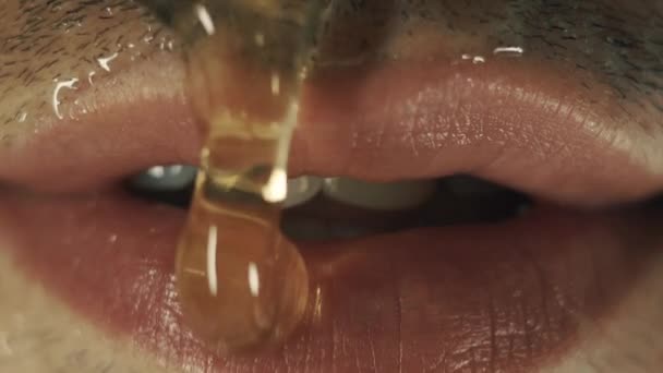 Męskie usta z miodem. Zbliżenie na ustach - Materiał filmowy, wideo