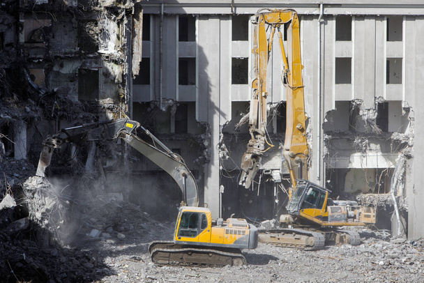 Building of the former hotel demolition for new construction, using a two special hydraulic excavator-destroyer. Complete highly mechanized demolition of building structures. Construction site - Photo, Image