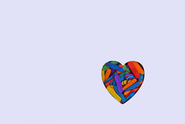 Corazón hecho de palos de madera de colores. Fondo mínimo día de San Valentín. - Foto, imagen