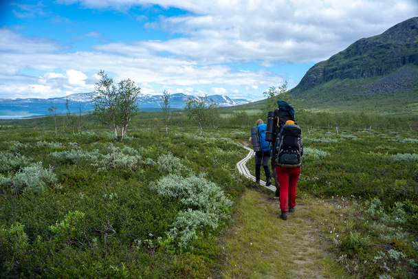 Padjelanta National Park, Beautiful Mountain Scenery and Hiking Trails leading away from Camera with group of hikers trekking and living the wanderlust dream. - Photo, Image