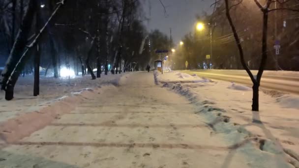 lumen peittämä ilta katu kaupungin, sataa voimakkaasti lunta - Materiaali, video