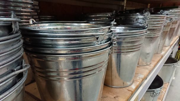 Metal galvanized buckets stand on the shelf - Photo, Image