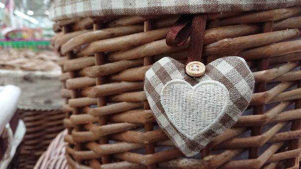 Maravilloso y lindo corazón de tejido unido a una cesta trenzada - Foto, imagen