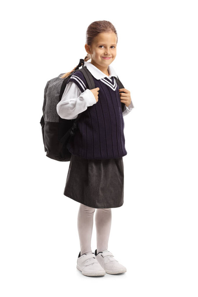 Full length portrait of a smiling schoolgirl in a uniform isolated on white background - Foto, Imagem