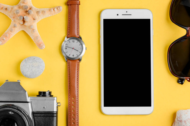 Phone, camera, watches and sunglasses. Starfish and pebbles - Valokuva, kuva