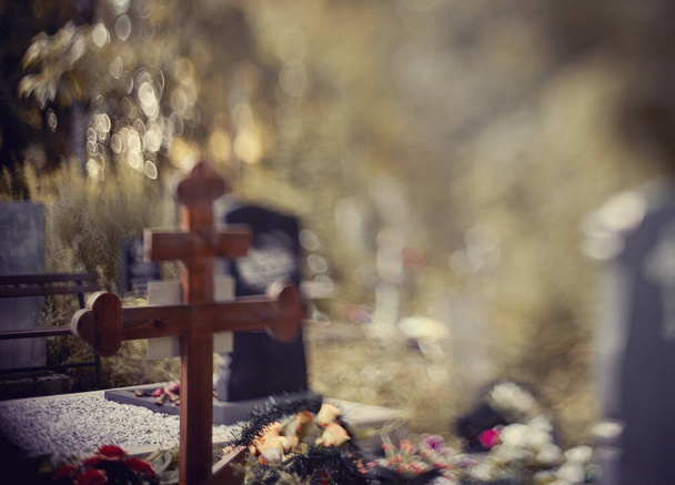 Blurry background with a cross on a grave behind a fencing. It is photographed in the Free-Lensing equipment. - Foto, Bild